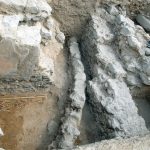 צינור חרס מכוסה בטיט עם אבנים
